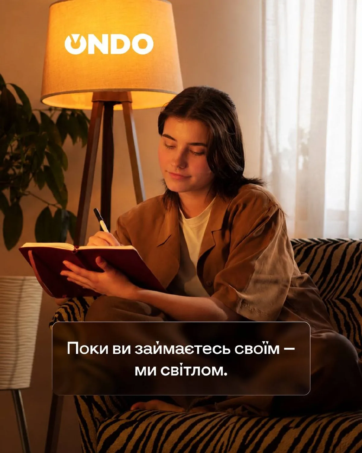 Жінка читає документ під лампою UNDO в кімнаті