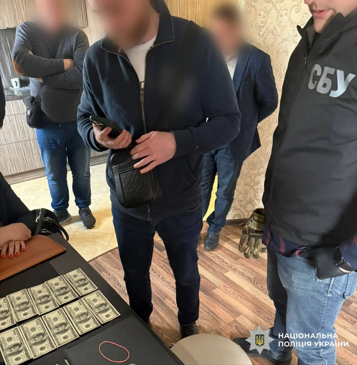 Поліцейські демонструють вилучені грошові купюри під час операції