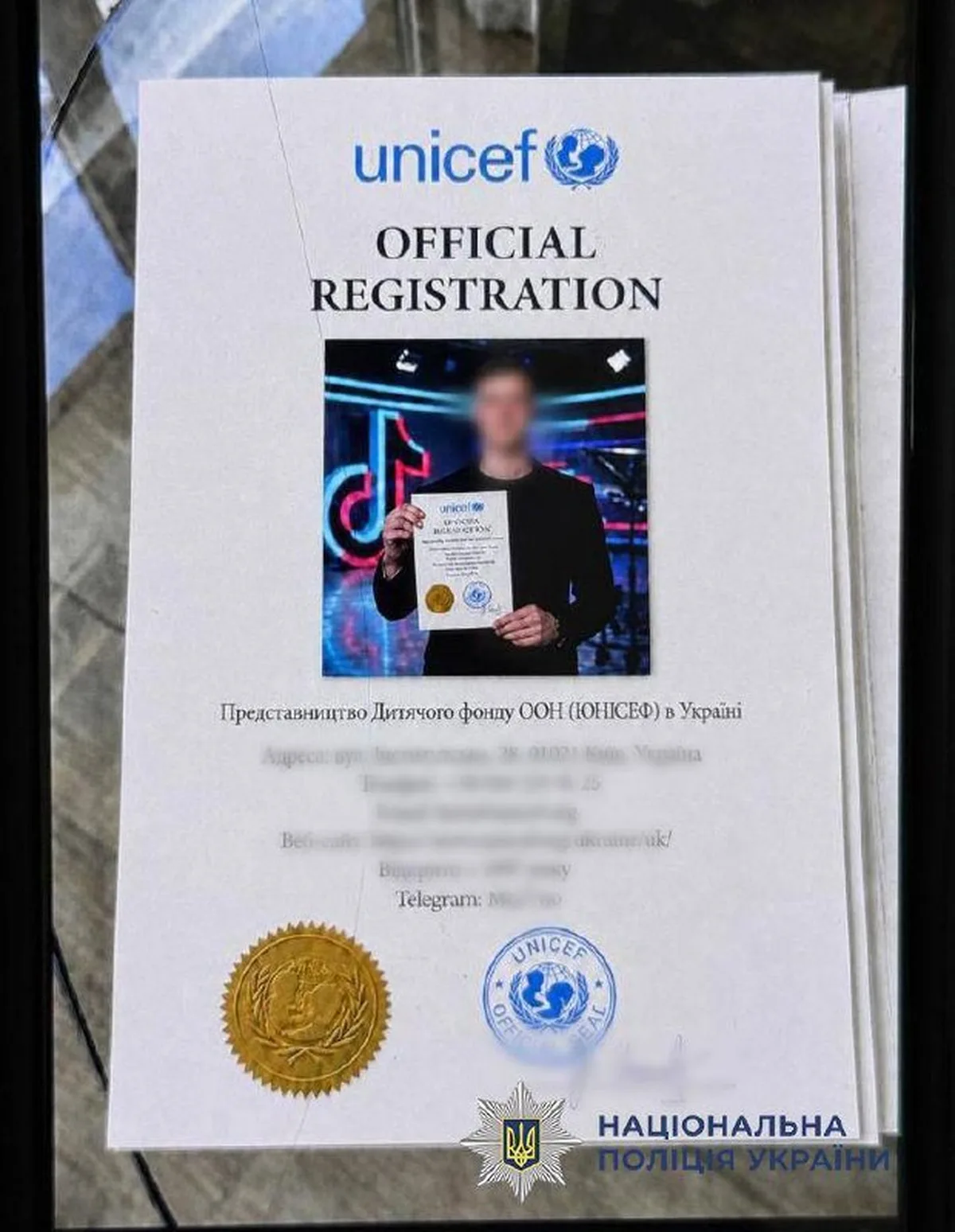 Документ UNICEF з печатками та фотографією особи, використаний у шахрайській схемі