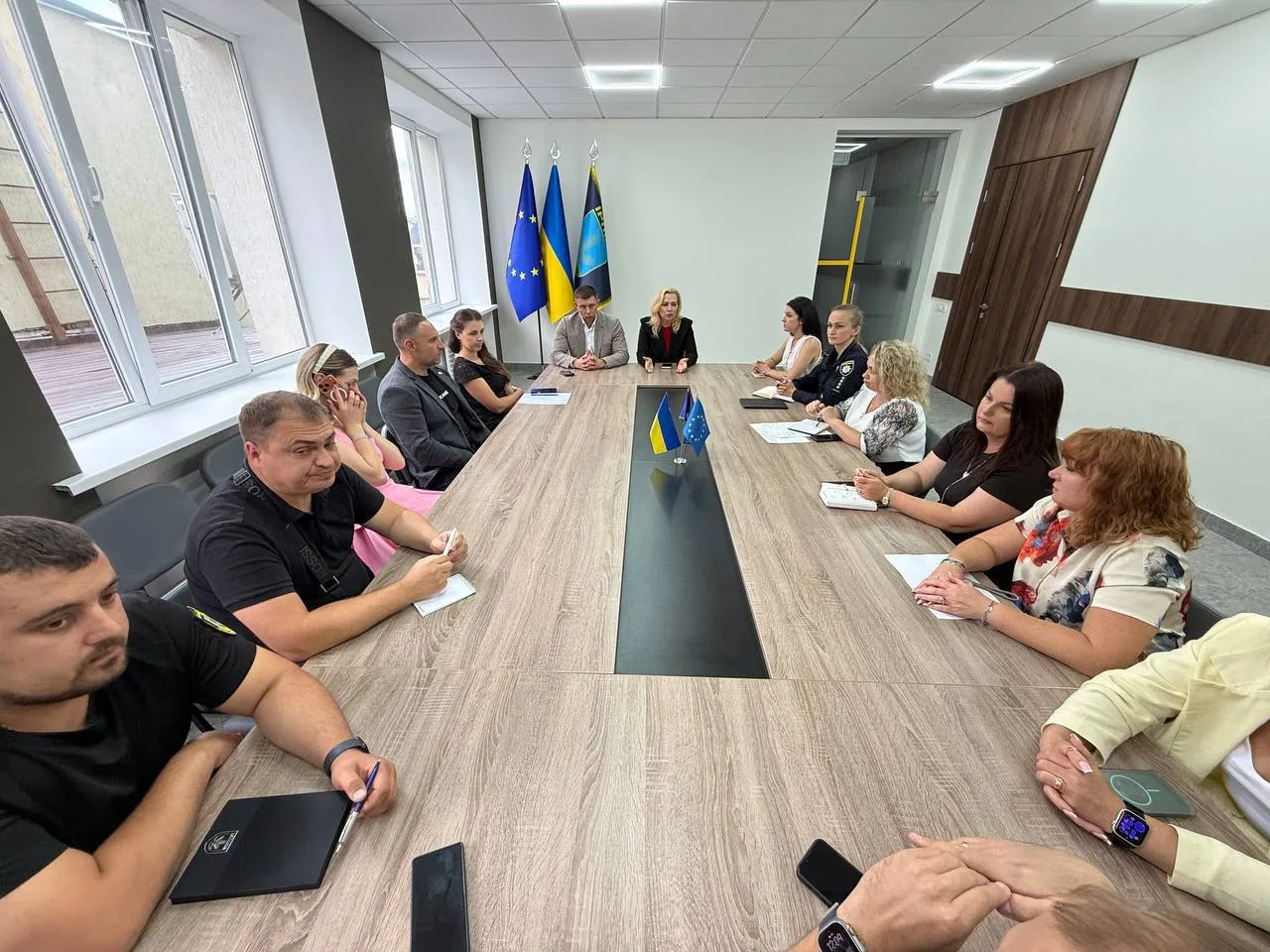 Люди сидять за довгим столом на засіданні