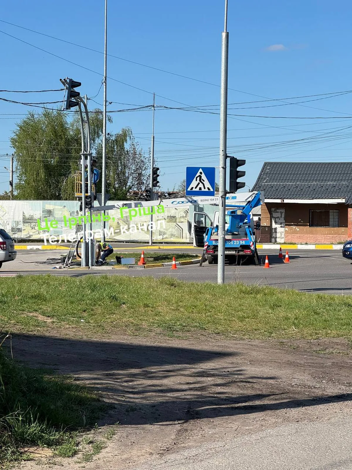 Робітники встановлюють світлофор на перехресті в Романівці