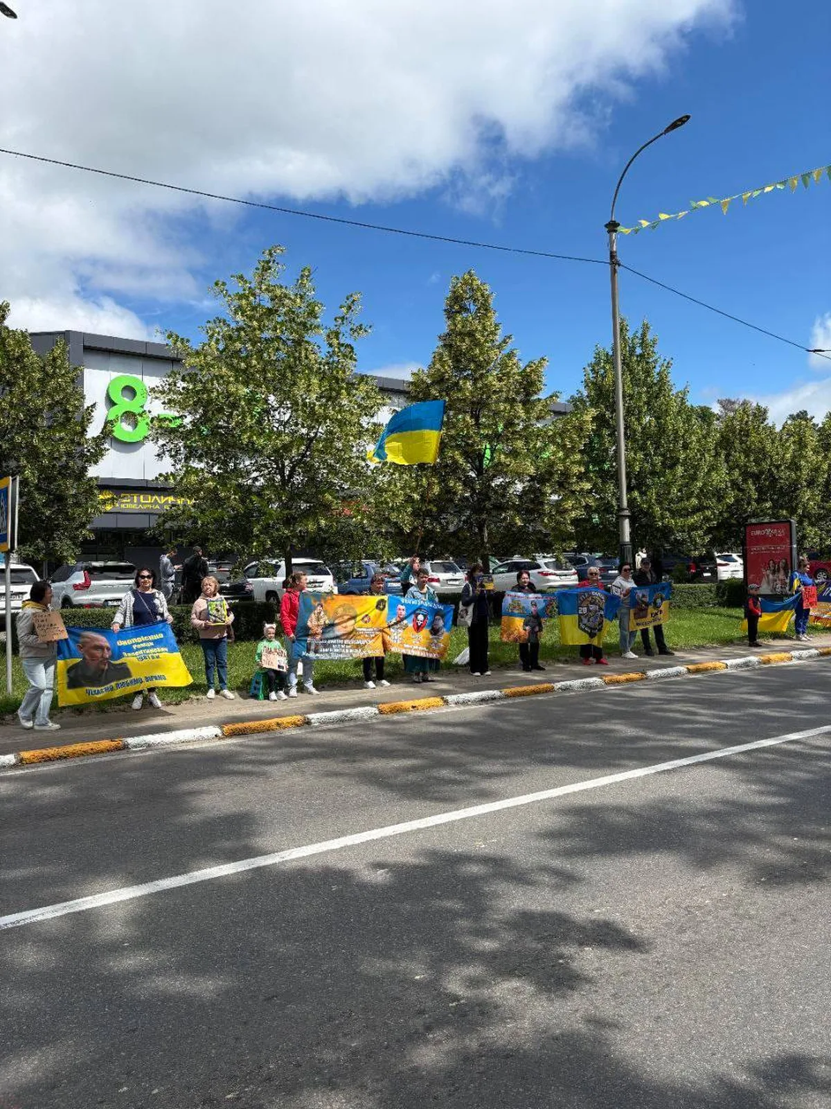 Люди з українськими прапорами на вулиці міста