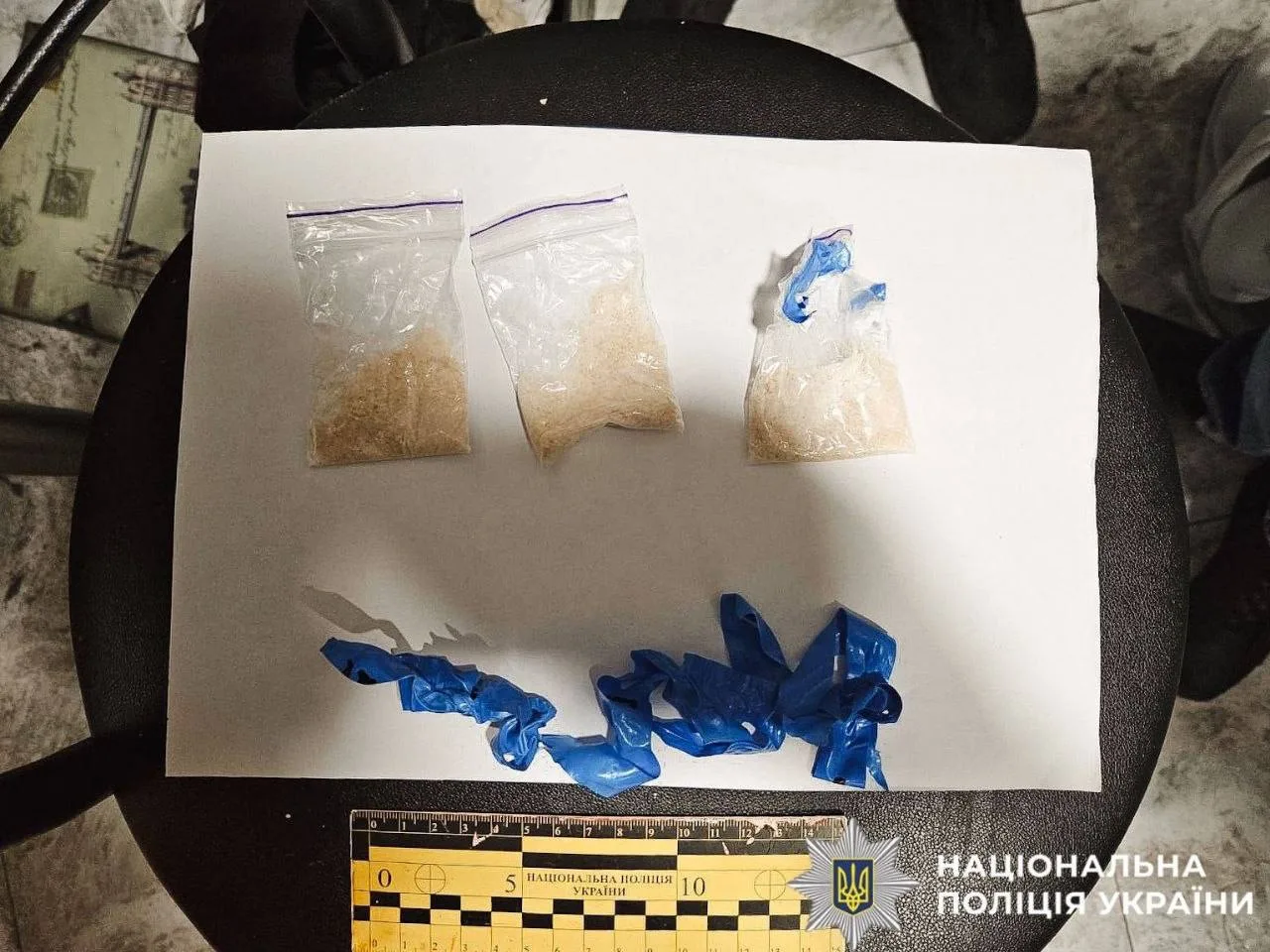 Три пакети з порошкоподібною речовиною та синіми капсулами на білому листі
