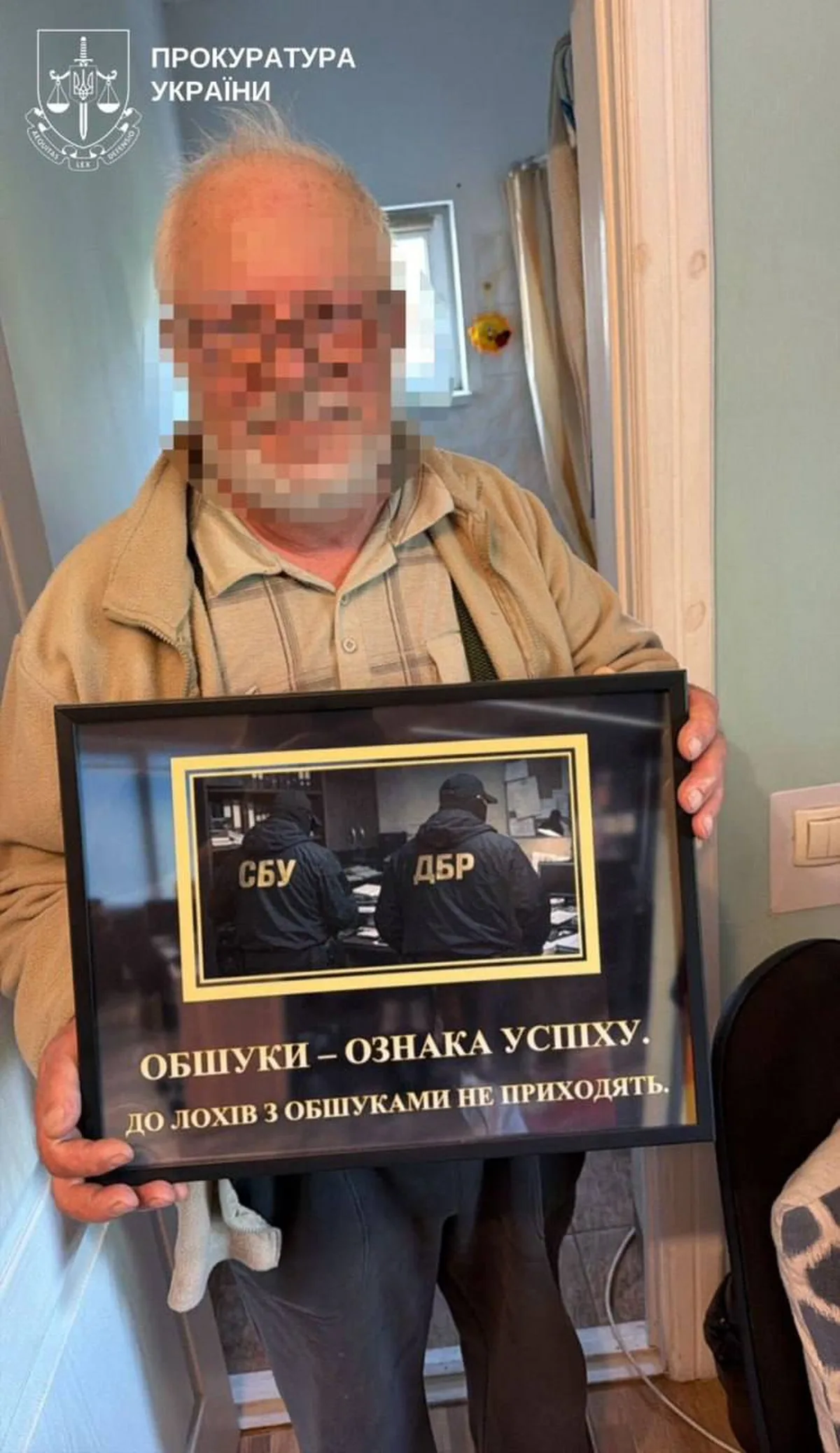 Чоловік тримає плакат з фото осіб та написом про СБУ