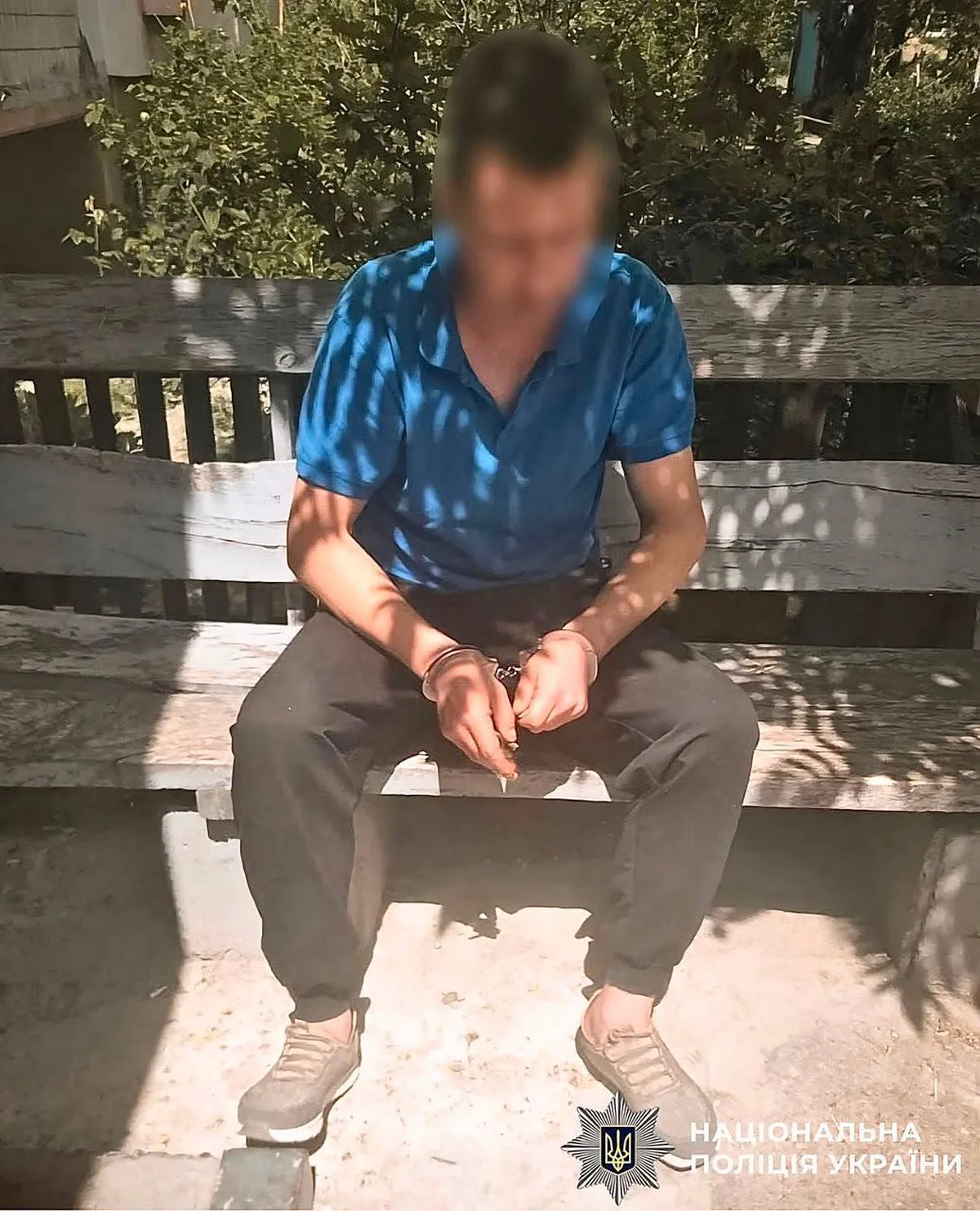 Чоловік сидить на лавці з видимими синцями на руках