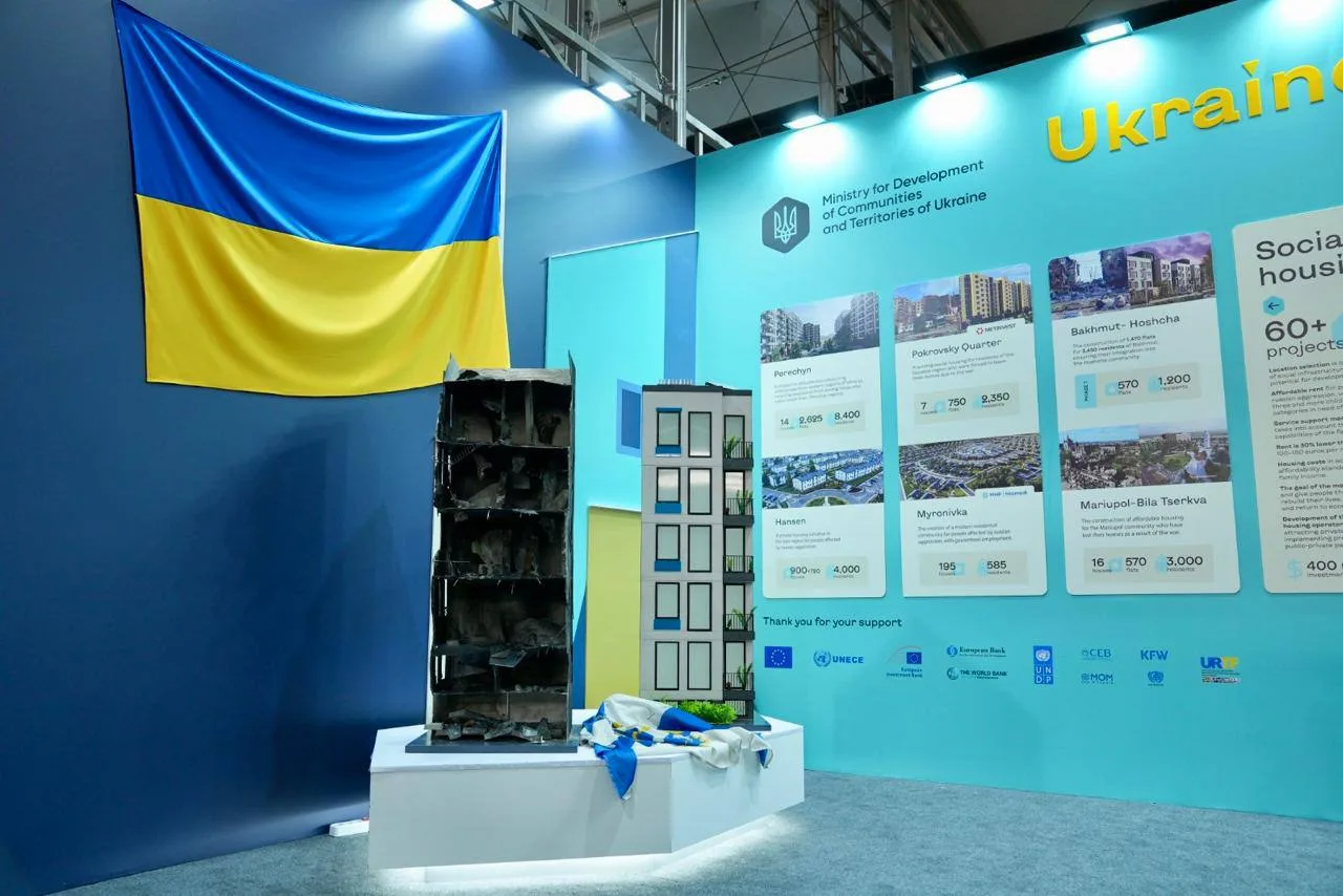Макет пошкодженої будівлі на постаменті під українським прапором