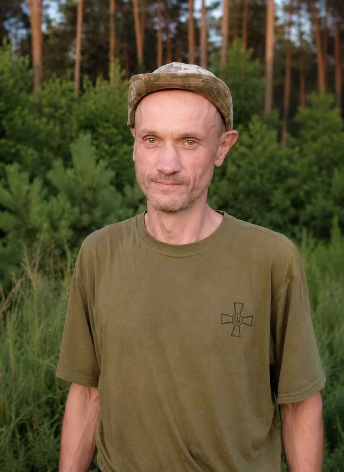 Чоловік у військовій формі на фоні лісу