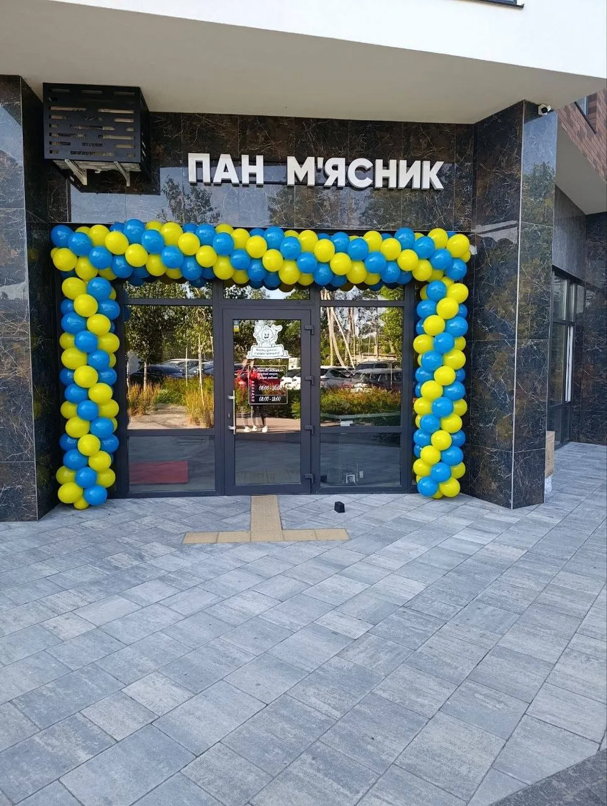 Вхід до магазину з синьо-жовтими повітряними кульками