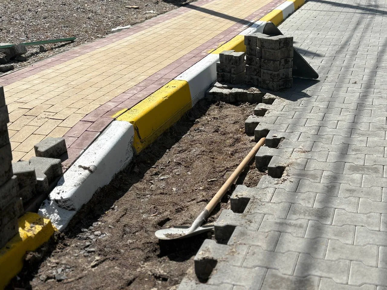 Пошкоджена бруківка та жовто-білий бар'єр на вулиці