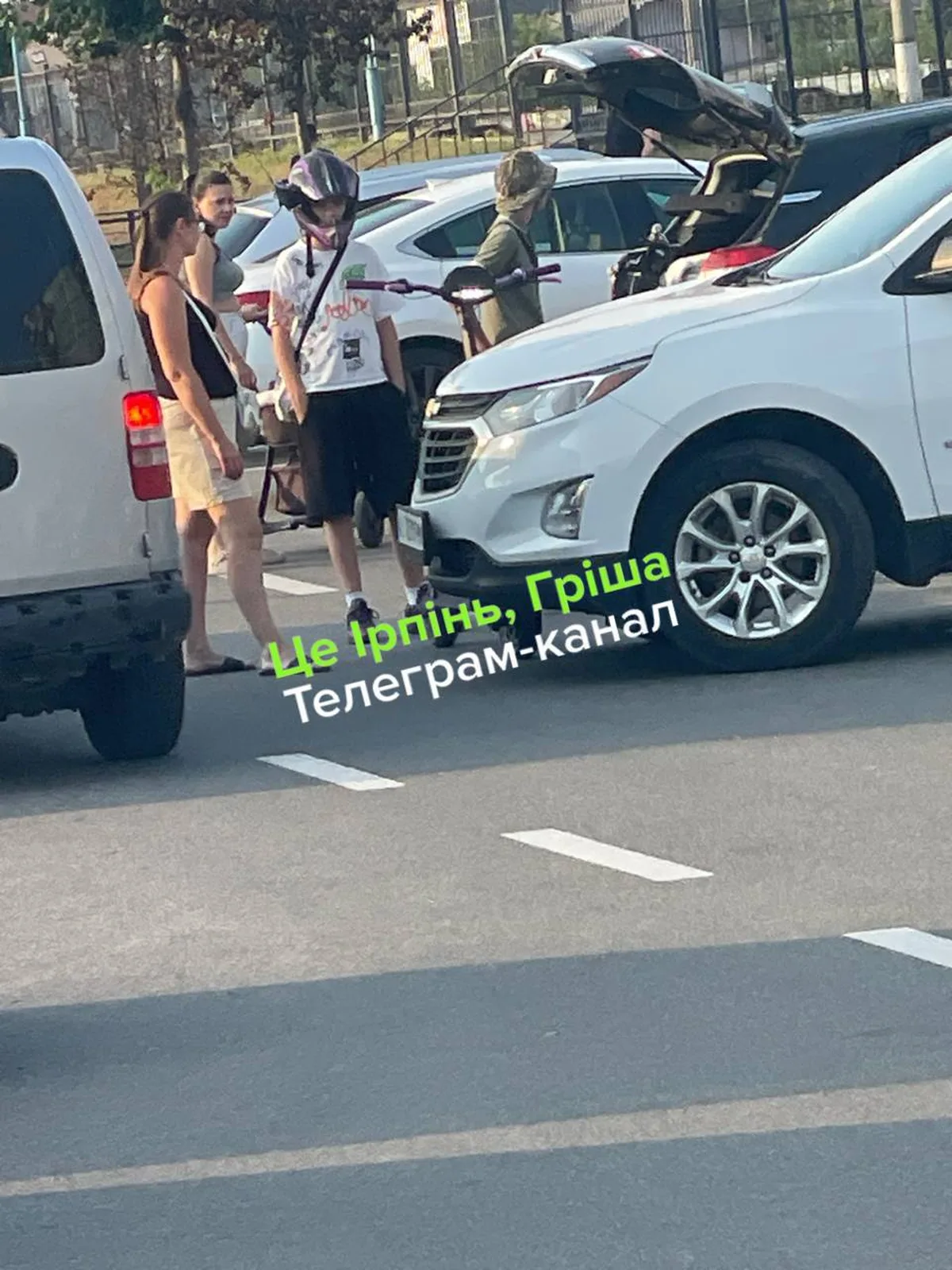 Люди біля пошкоджених автомобілів на парковці