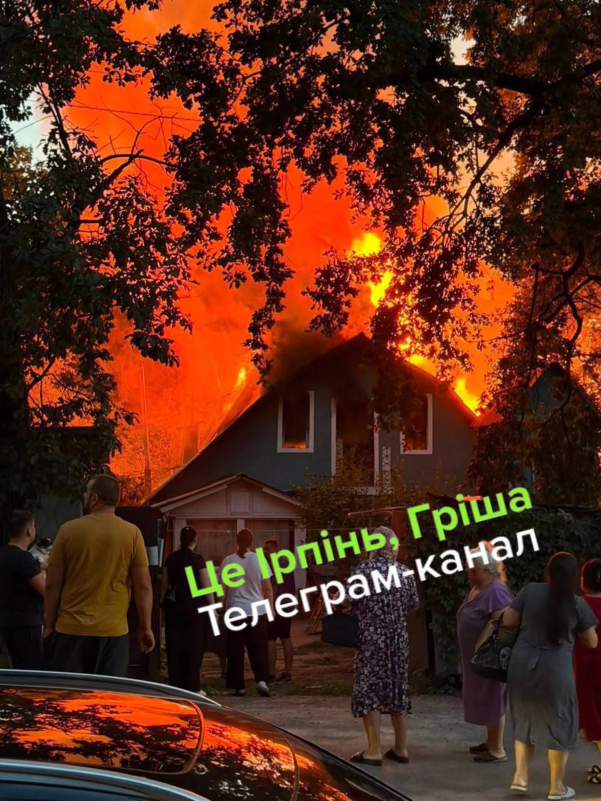 Люди спостерігають пожежу в житловому будинку вночі