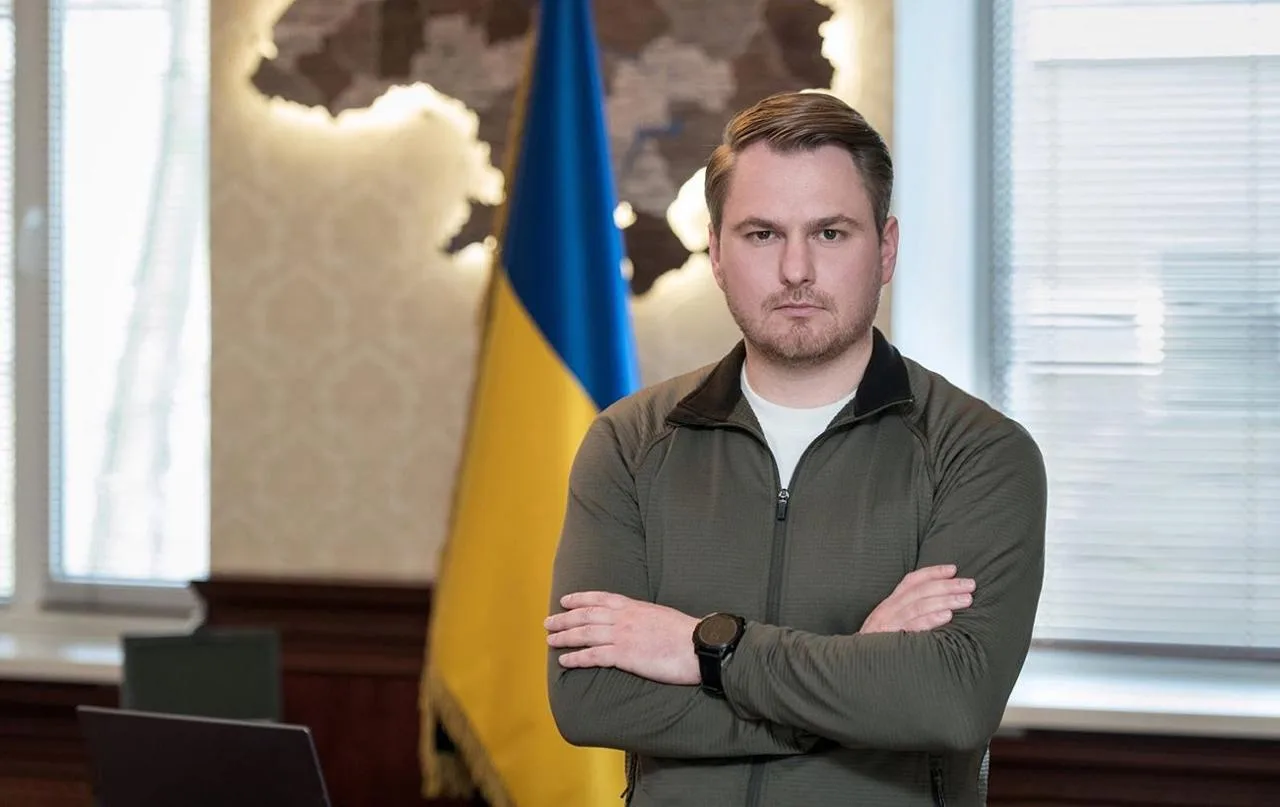 Чоловік у військовій формі біля прапора України