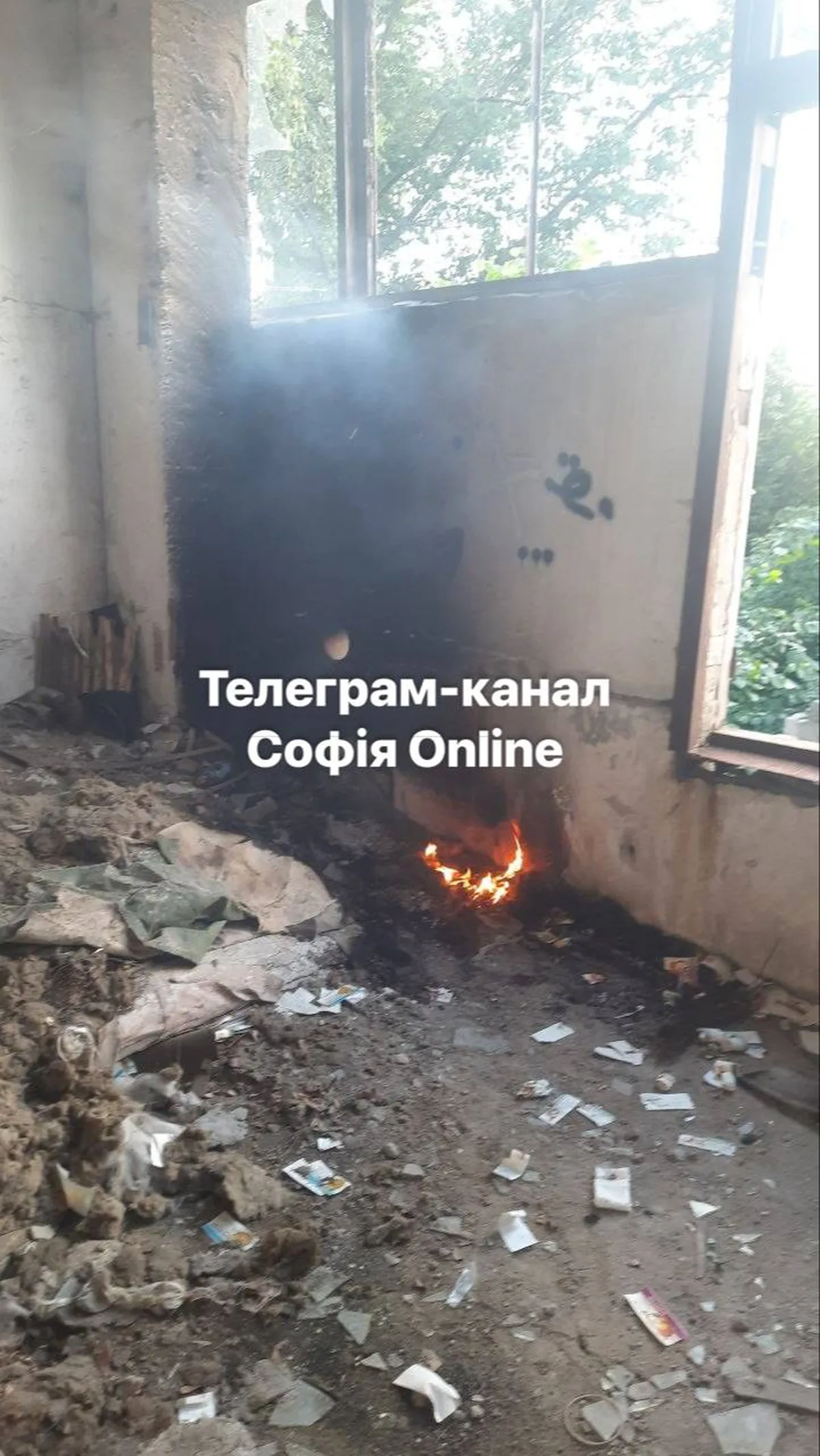 Пошкоджена будівля з вогнем на підлозі біля вікна