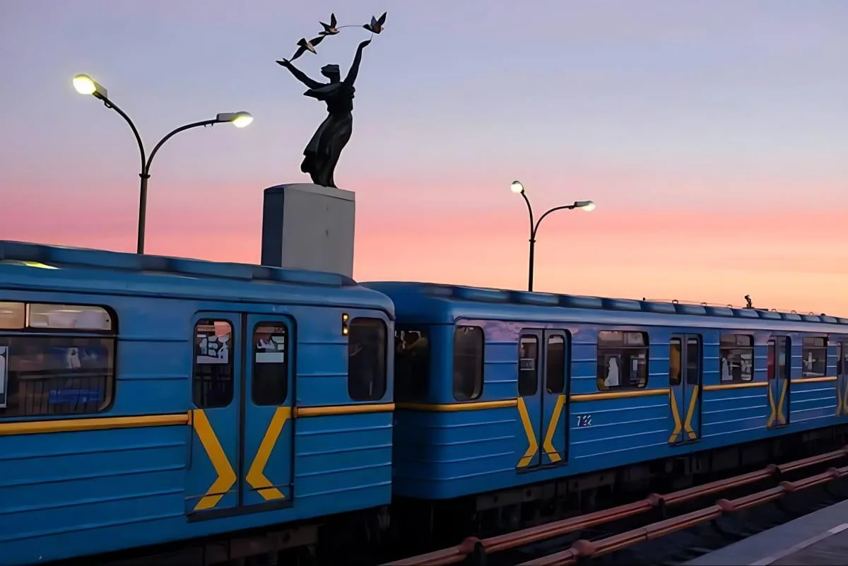 Синій вагон метро з монументом на платформі