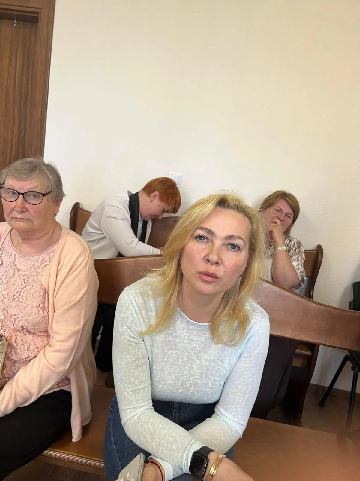 Люди сидять на лавці в залі суду