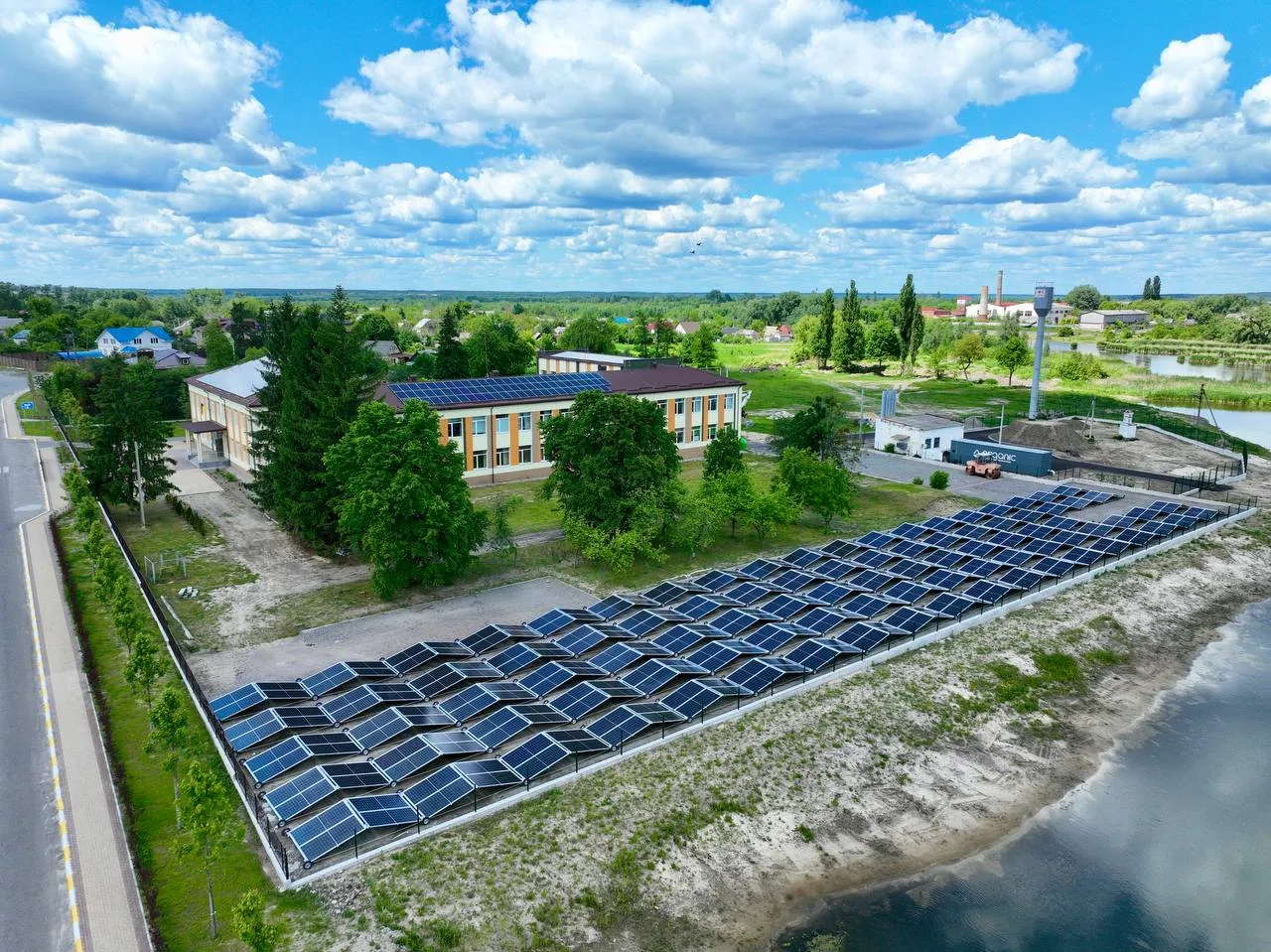 Сонячна електростанція біля будівлі на березі річки