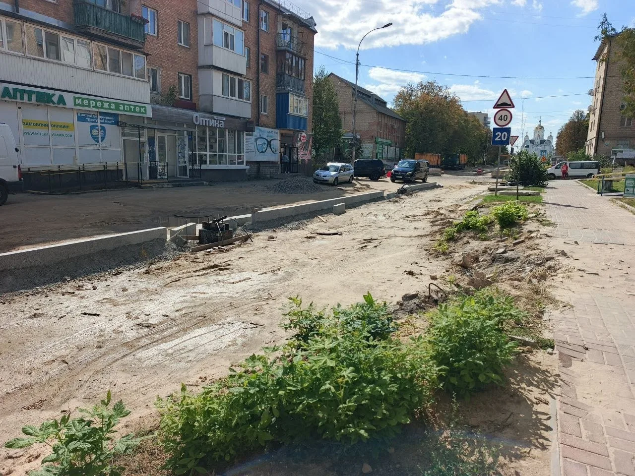 Вулиця з пошкодженою дорогою та будівлями під реконструкцію
