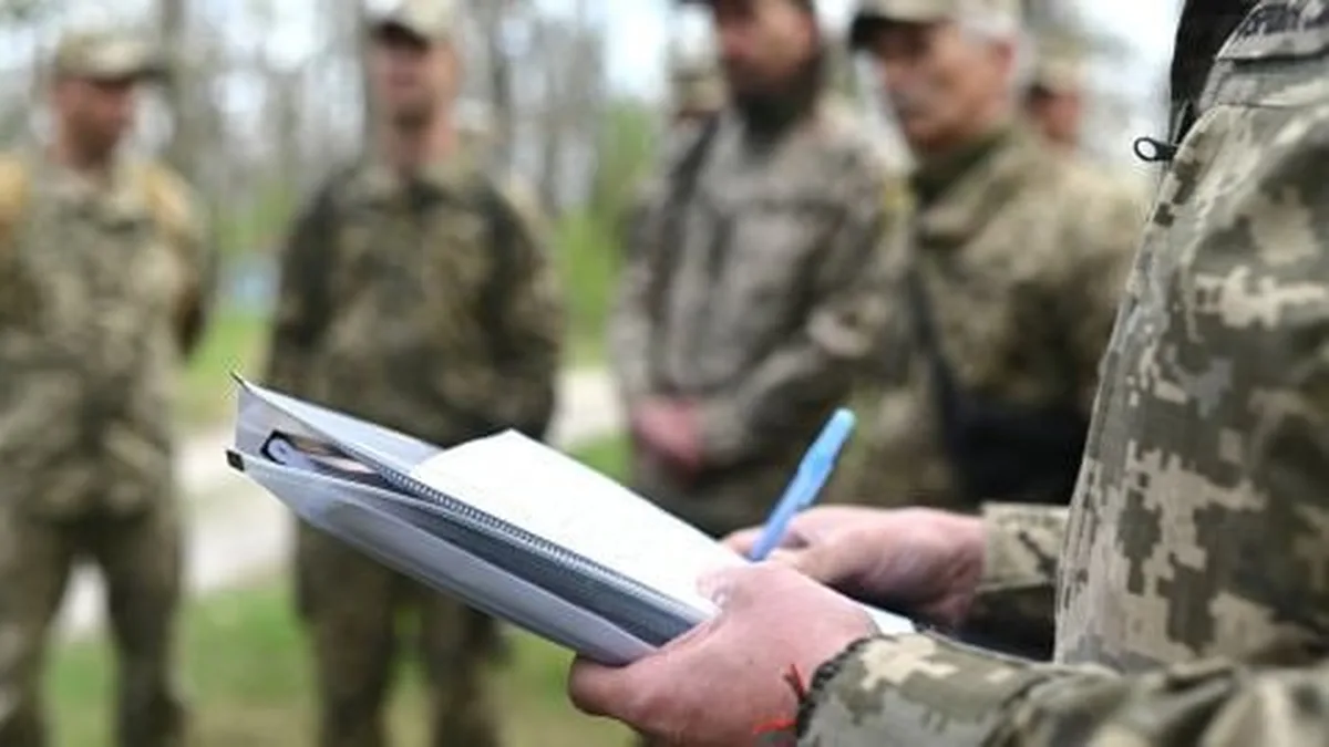 Військовослужбовець тримає папку під час брифінгу з колегами