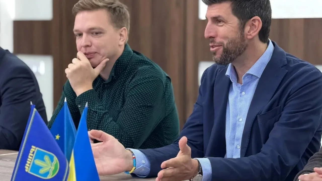Два чоловіки на зустрічі з прапорами Ірпеня та ЄС