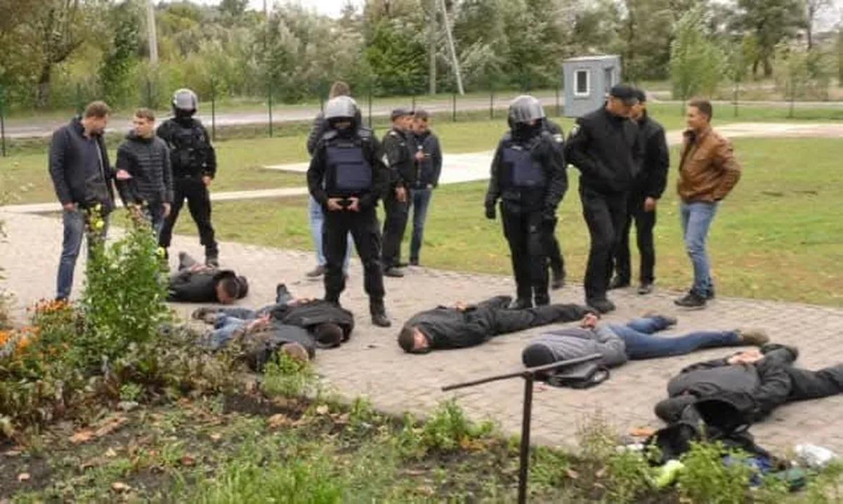 Люди в чорному екіпіруванні біля тіл на землі