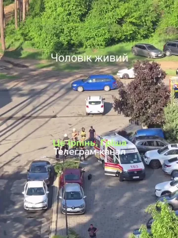 Вид з висоти на паркінг житлового комплексу з припаркованими автомобілями та машиною швидкої допомоги