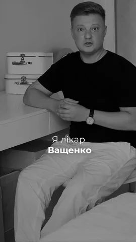 Лікар у чорній футболці сидить на ліжку в кабінеті