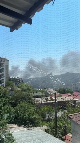 Дим над гірським містом, видно з балкона житлового будинку