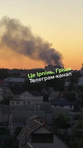 Дим над будівлями в Ірпені під час заходу сонця
