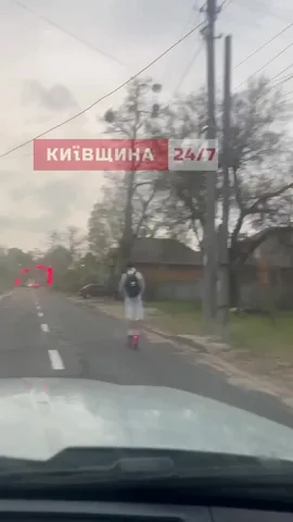 Вид з автомобіля на дорогу з людиною на електросамокаті
