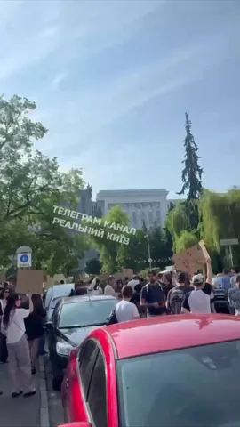 Люди на площі з плакатом біля будівель