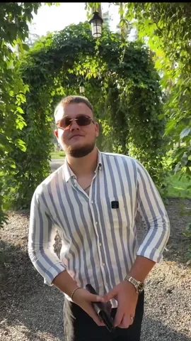 Чоловік у смугастій сорочці в саду