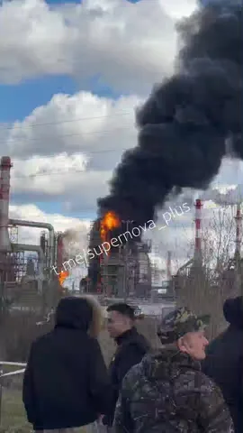 Люди спостерігають пожежу на промисловому об'єкті з чорним димом