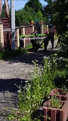 Чоловік на вулиці біля червоної огорожі та будинків