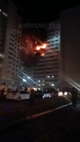 Пожежа у багатоповерховому будинку вночі, припаркована техніка