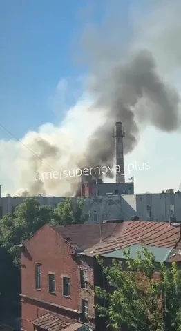 Дим над промисловим об'єктом у міській забудові