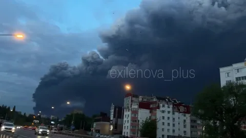 Густий чорний дим над промисловою зоною в сутінках