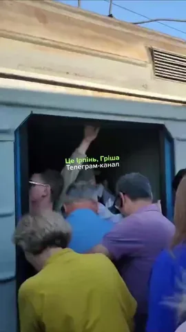 Люди в масках чекають біля входу до поїзда