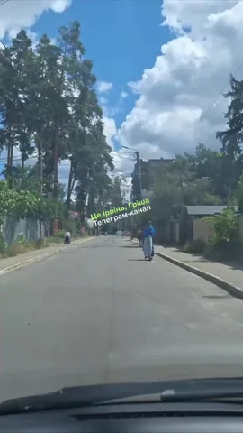 Вулиця з припаркованим автомобілем, людина на самокаті