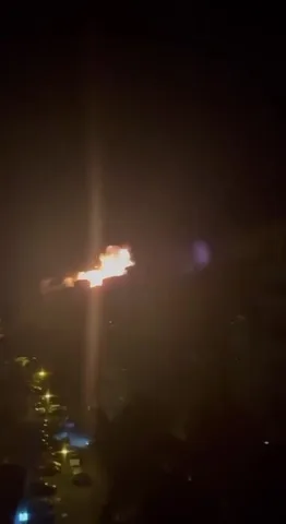 Вогняна куля в нічному небі над будинками