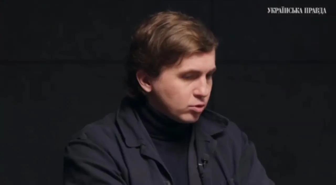 Молодий чоловік у темному піджаку на чорному фоні