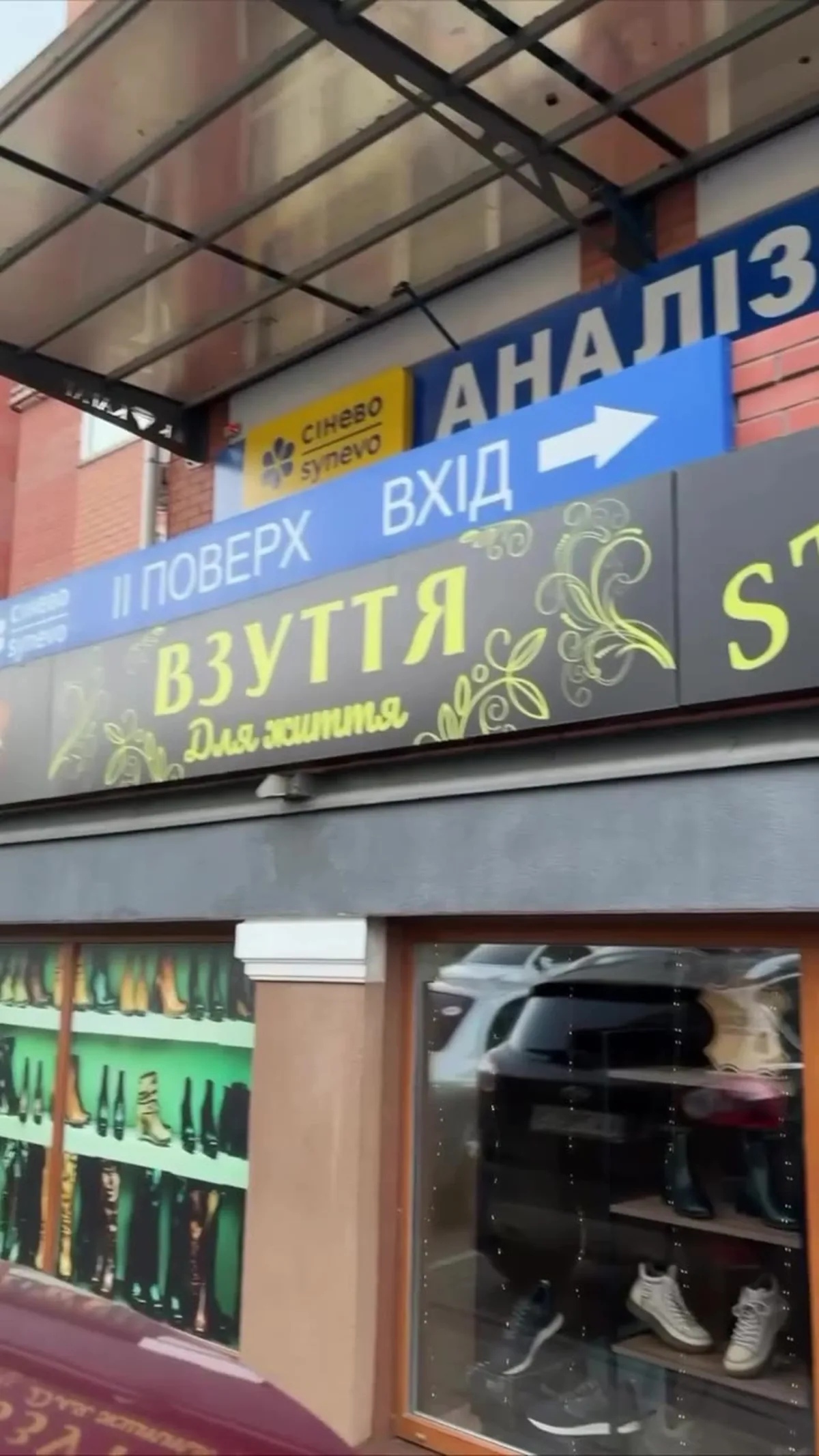 Вивіска магазину взуття з указівниками входу та напрямків