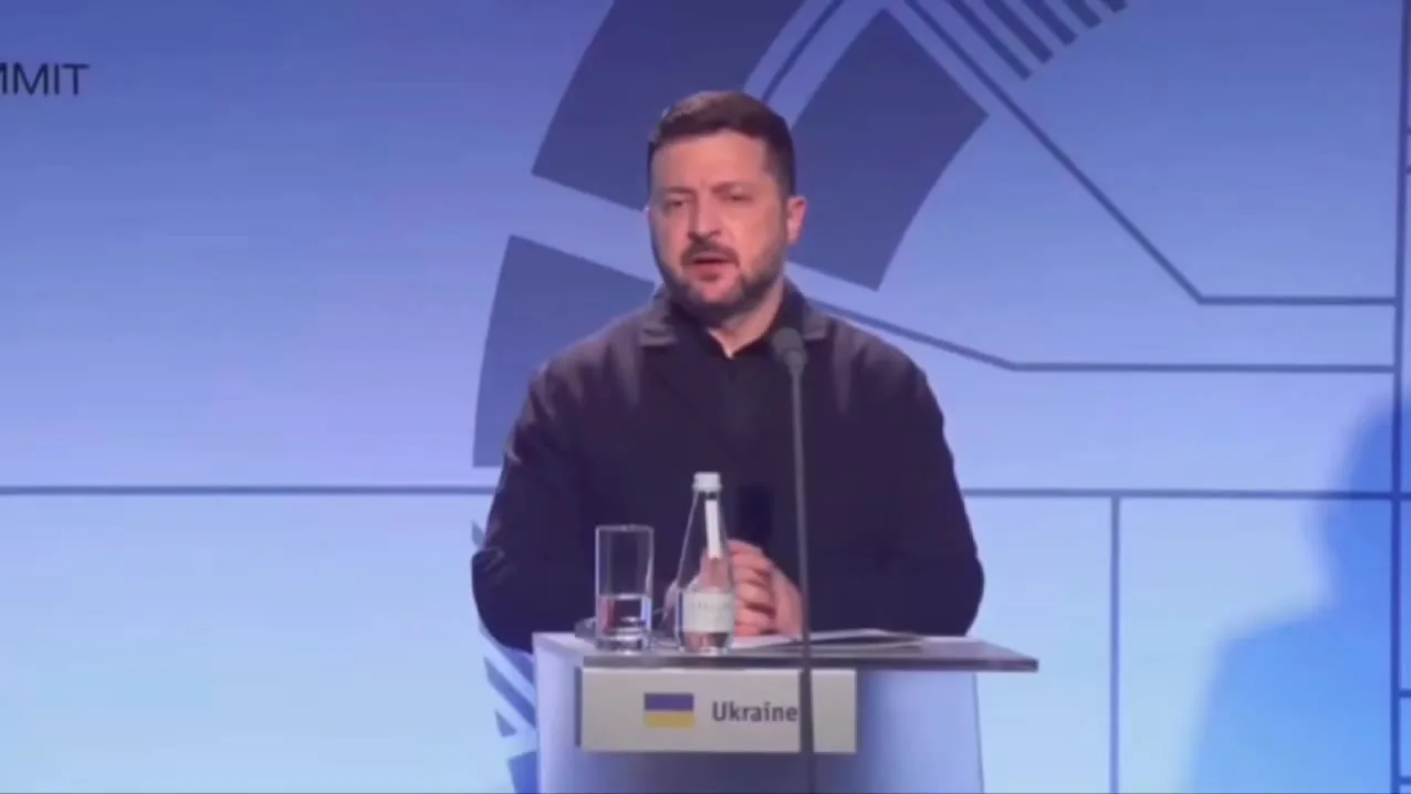 Чоловік у чорній сорочці за трибуною з табличкою України