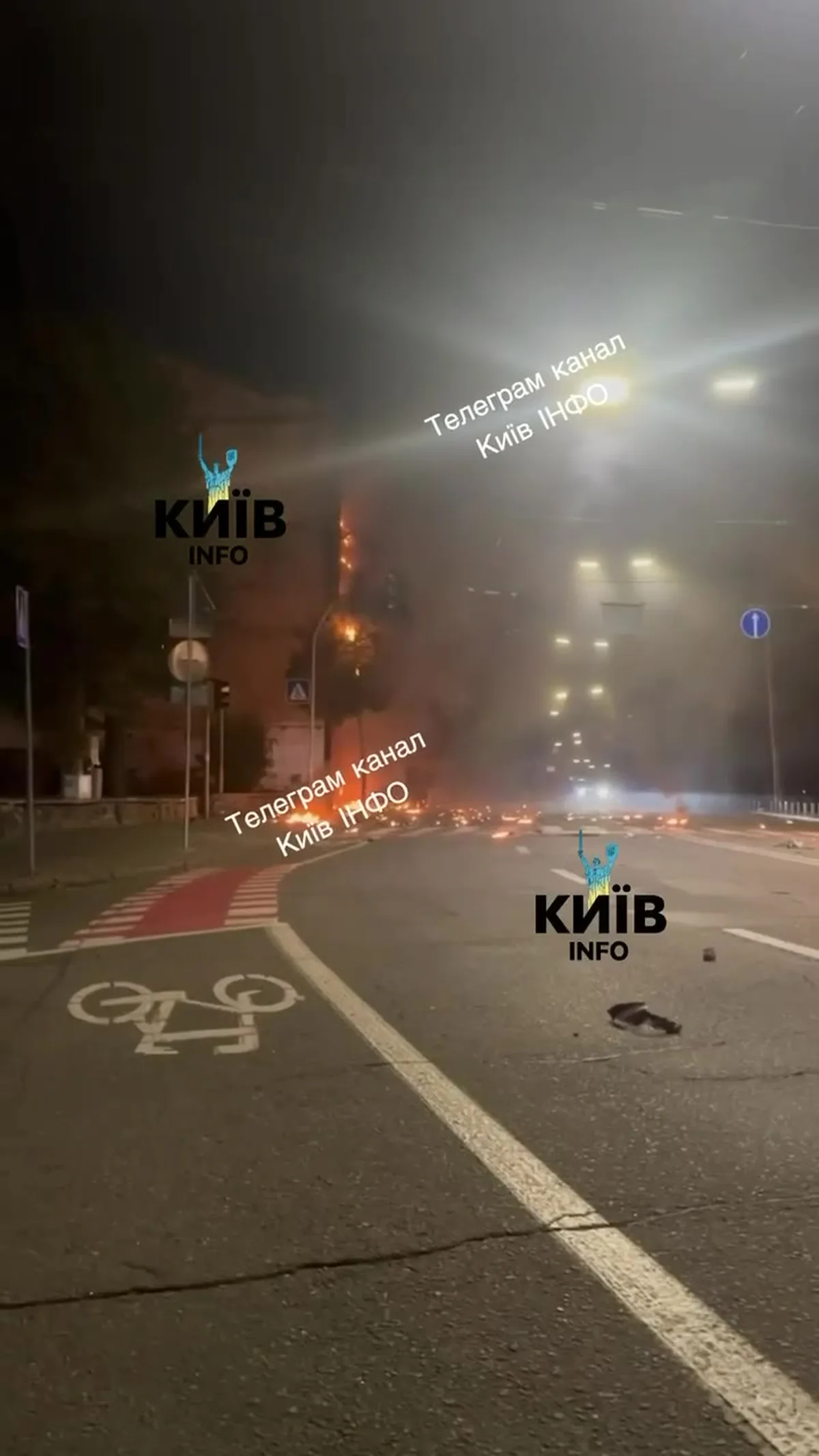 Нічна вулиця Києва з пошкодженою будівлею та світлами