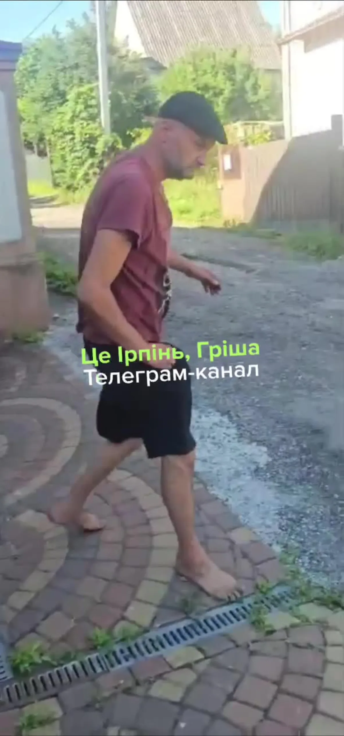 Чоловік у бордовій футболці на вулиці з зброєю