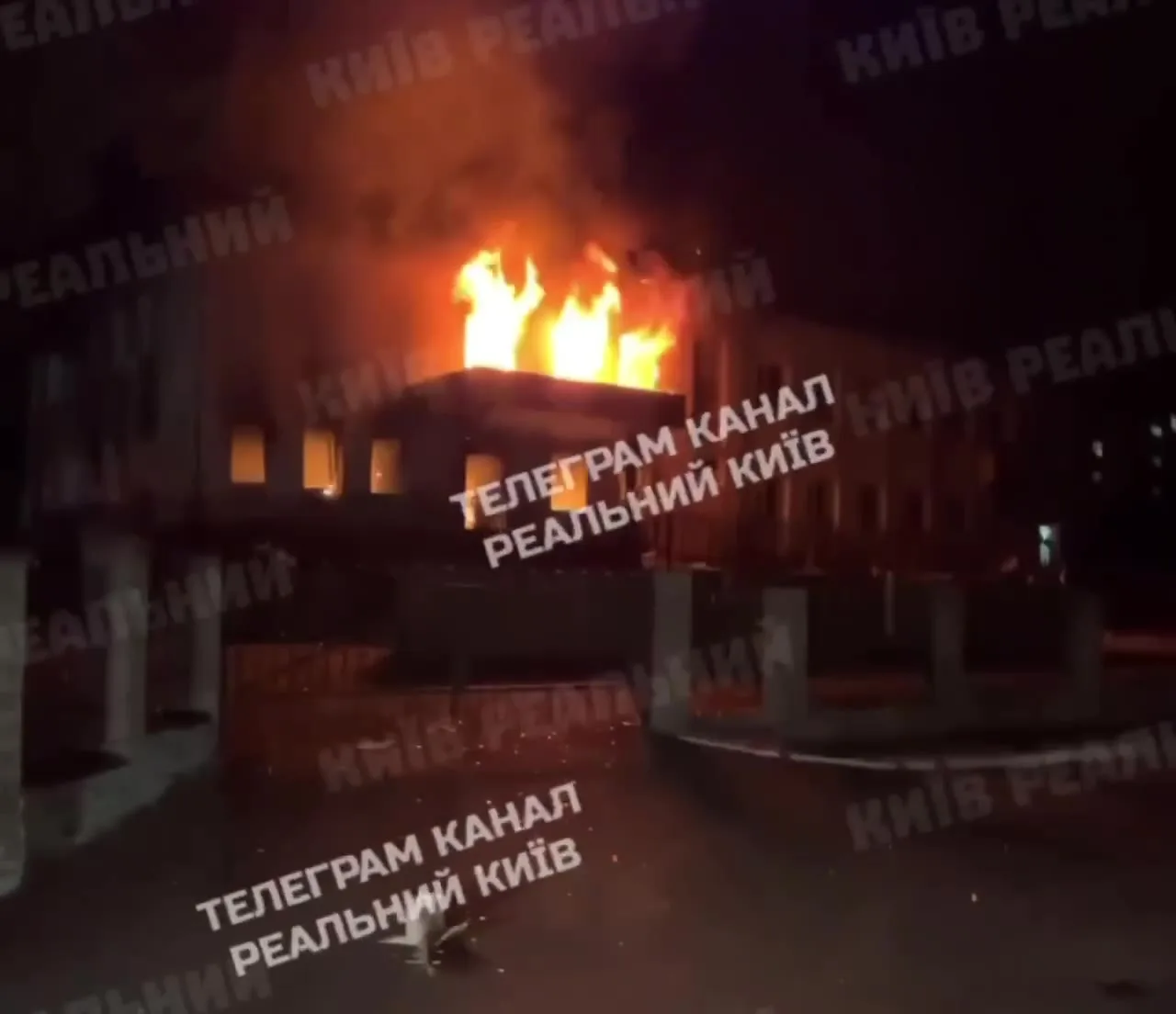 Будівля ліцею з вогнем на даху вночі