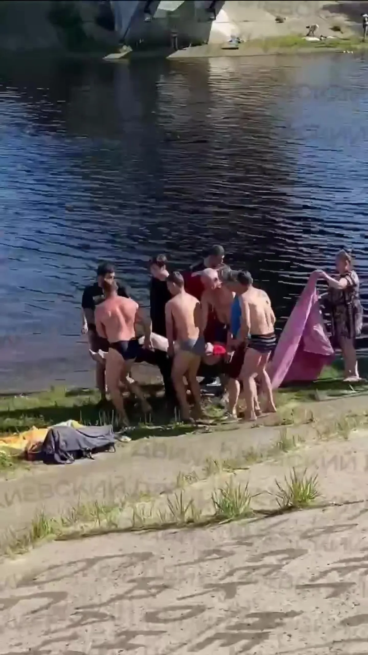 Група людей на пляжі біля води з човном