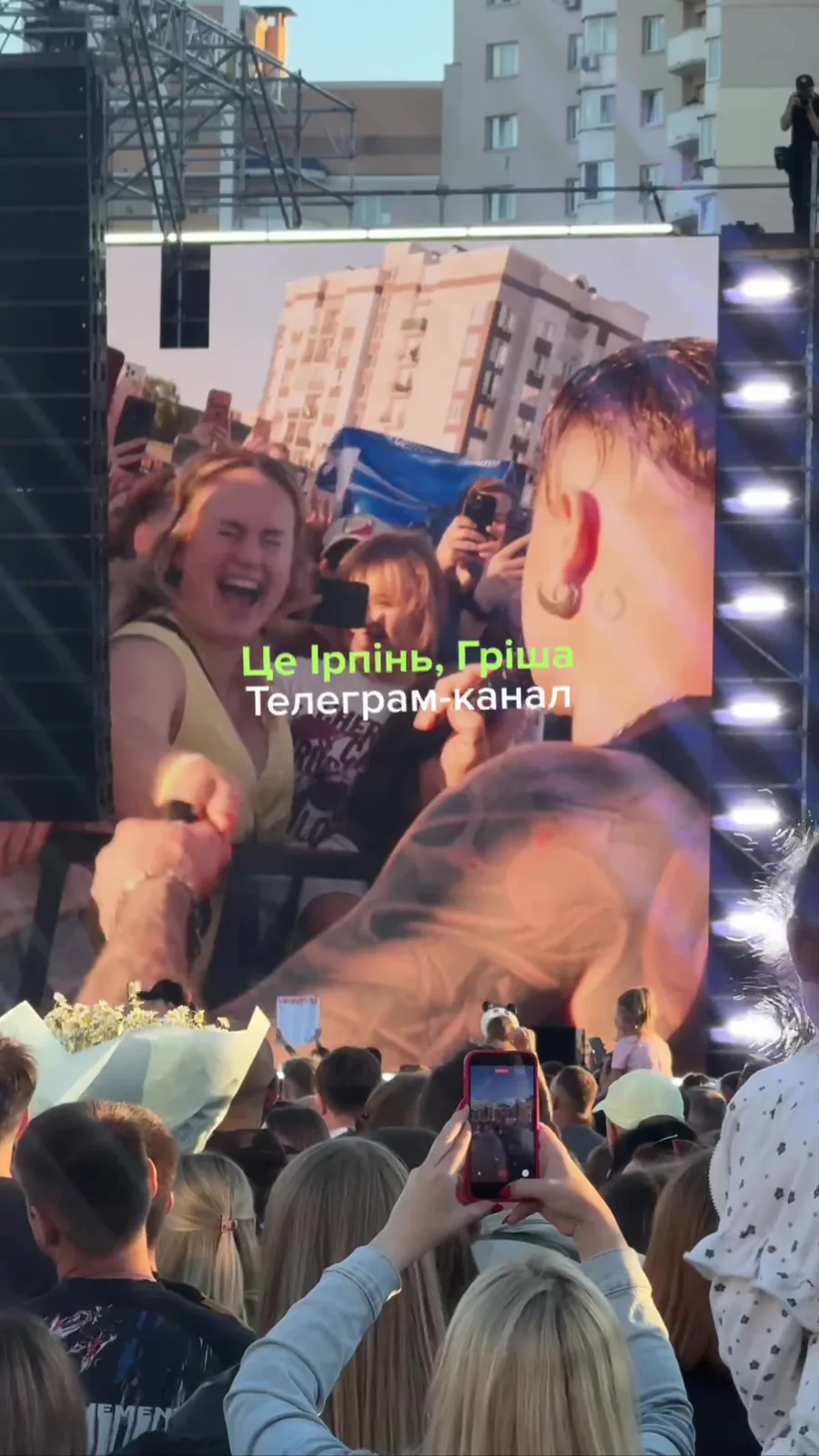 Люди на вулиці біля великого екрана з трансляцією