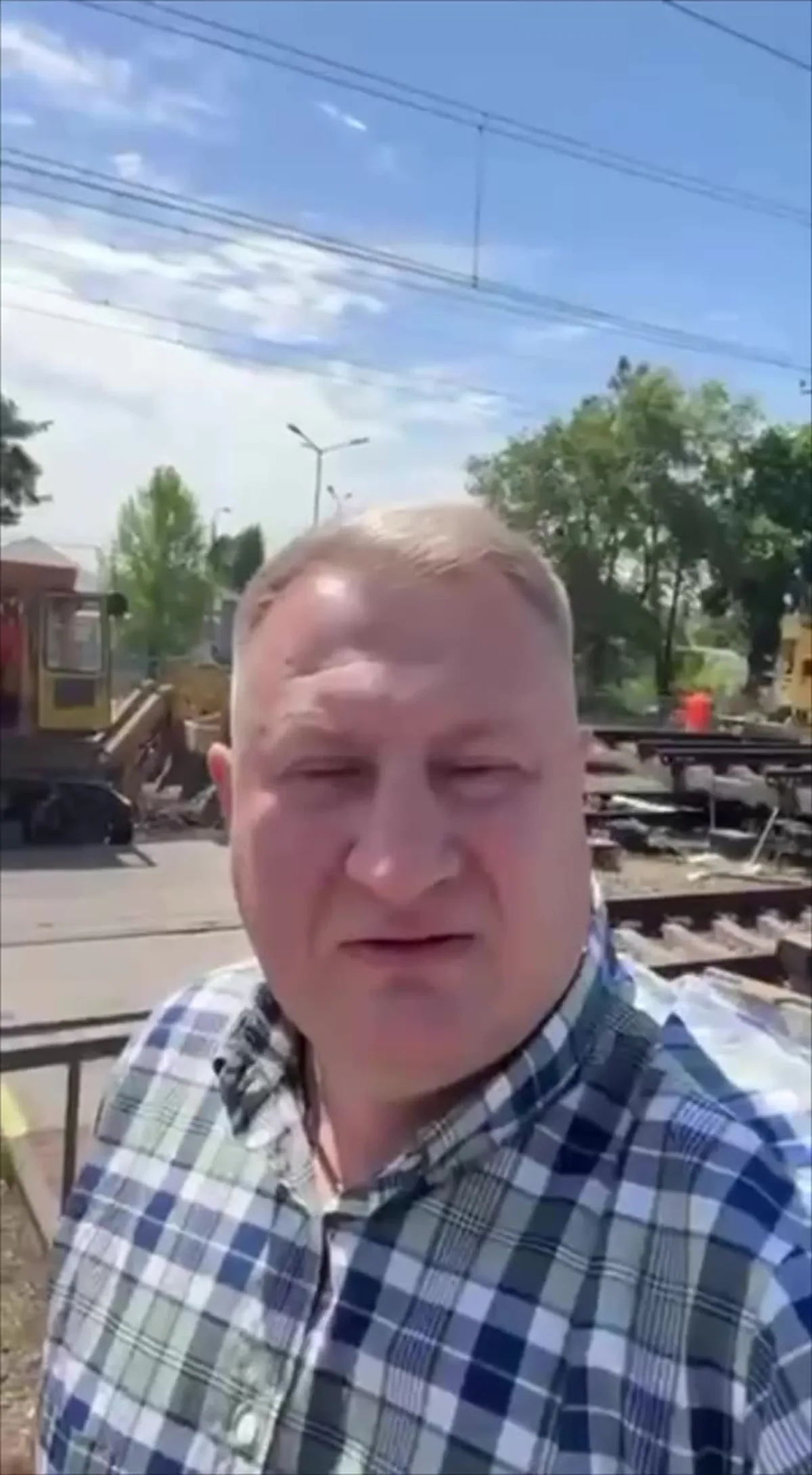 Чоловік у клітчастій сорочці на залізничній станції