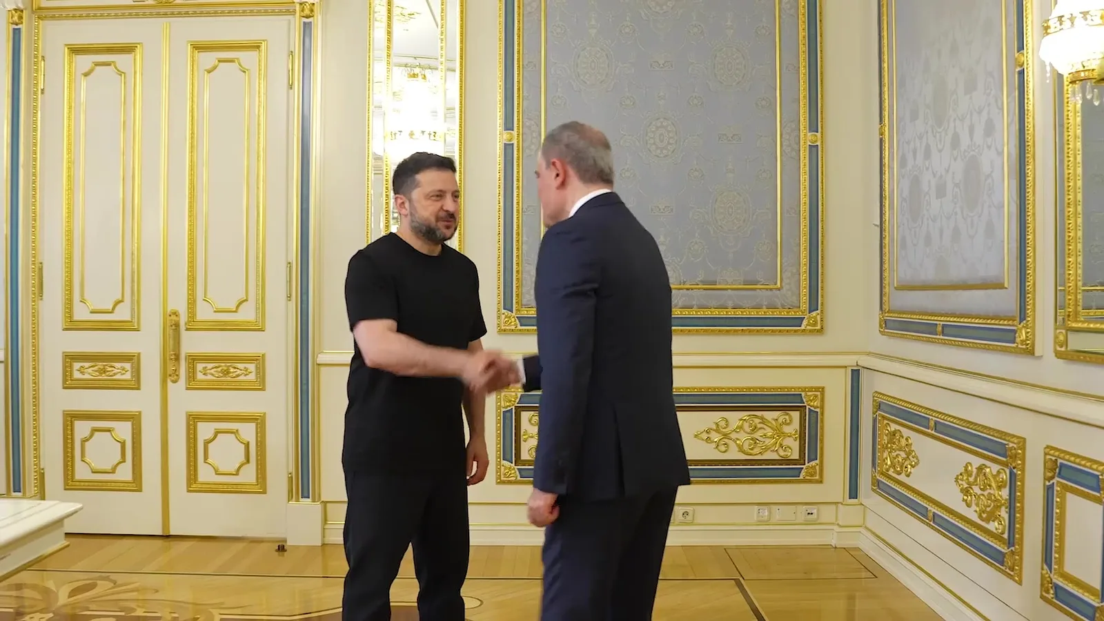 Два чоловіки в офіційному костюмі розмовляють в палаці