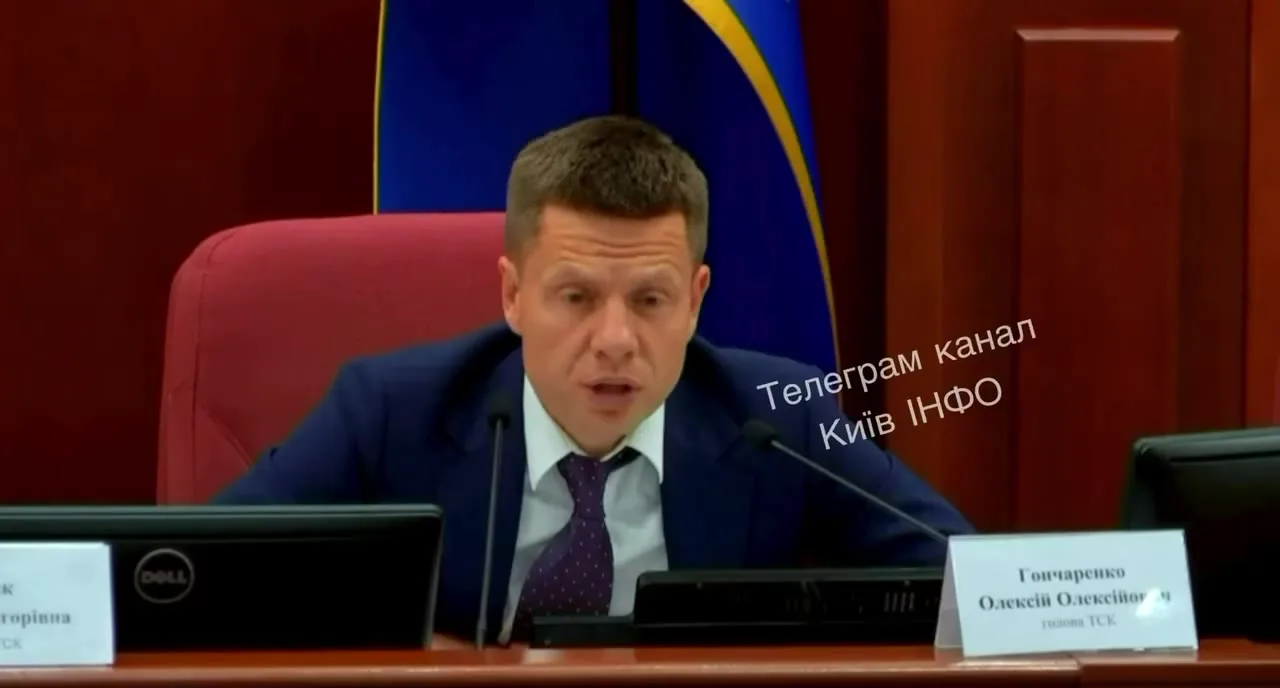 Чоловік у костюмі сидить за столом на засіданні
